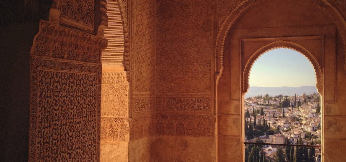 Moorish-style architecture featuring an arched window with a city visible in the distance