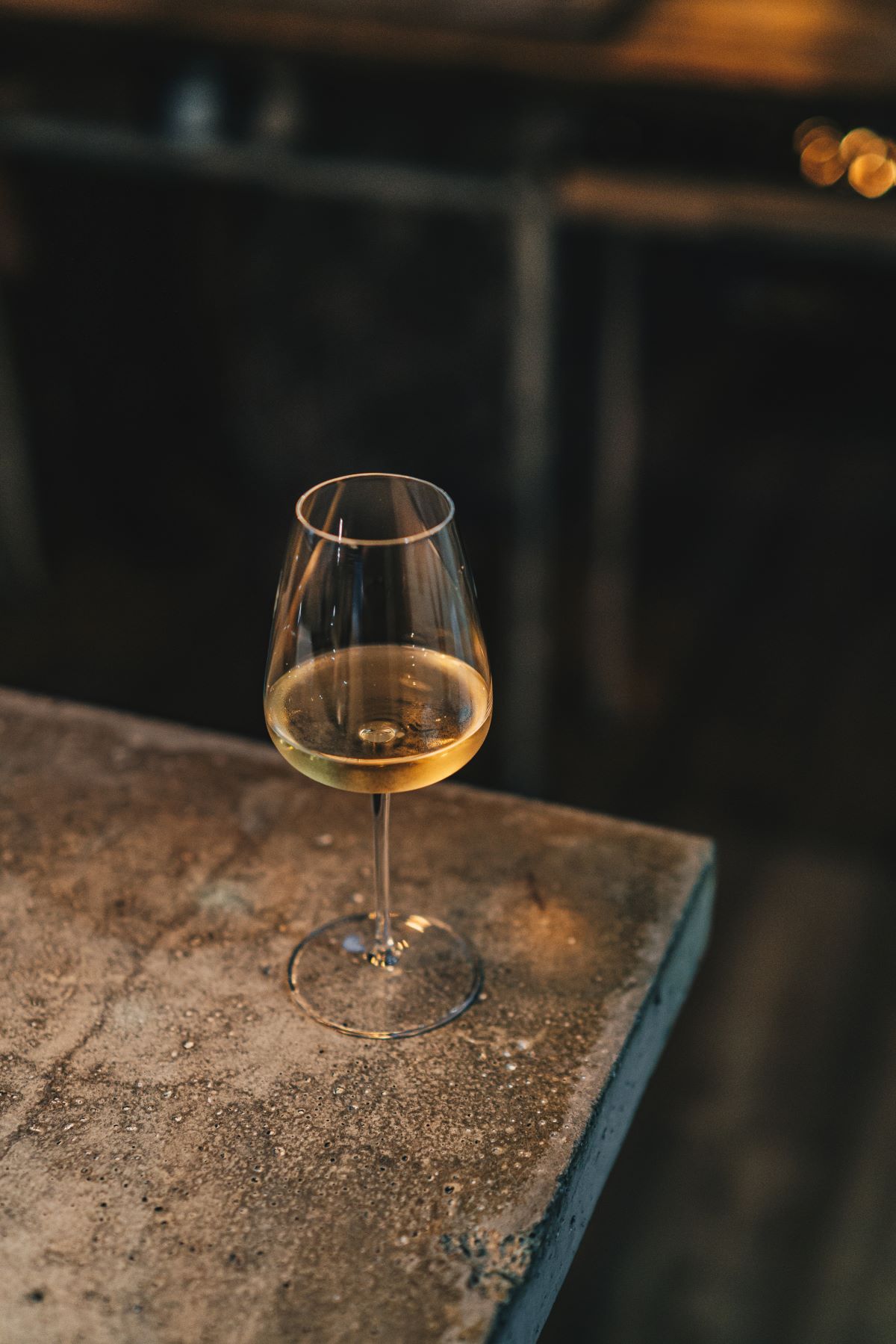 A glass of wine resting on a table.