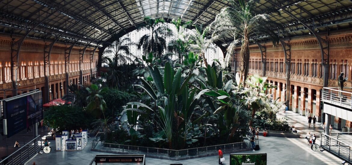 Interior of a train station with a large tropical garden