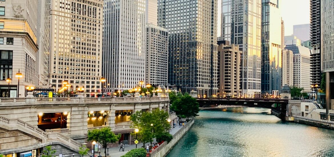 people walking along the Chicago riverwalk with skyscrapers in the background