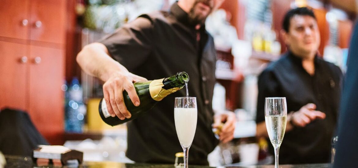 Bartender pouring two glasses of sparkling wine