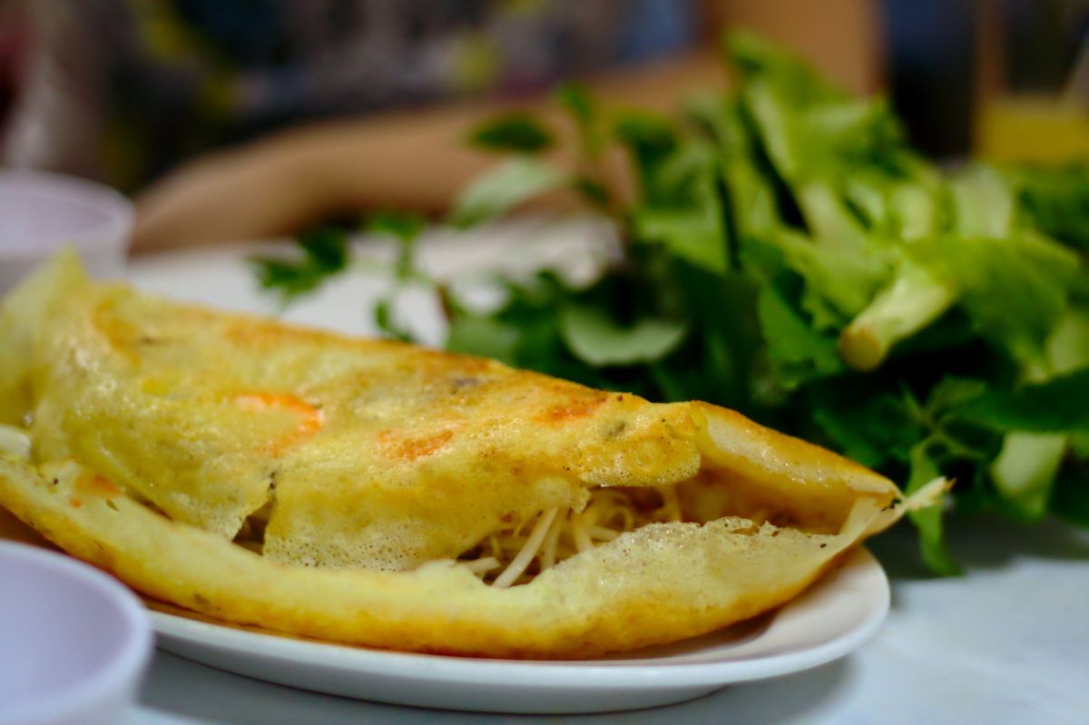 crepe with filled various veggies next to salad