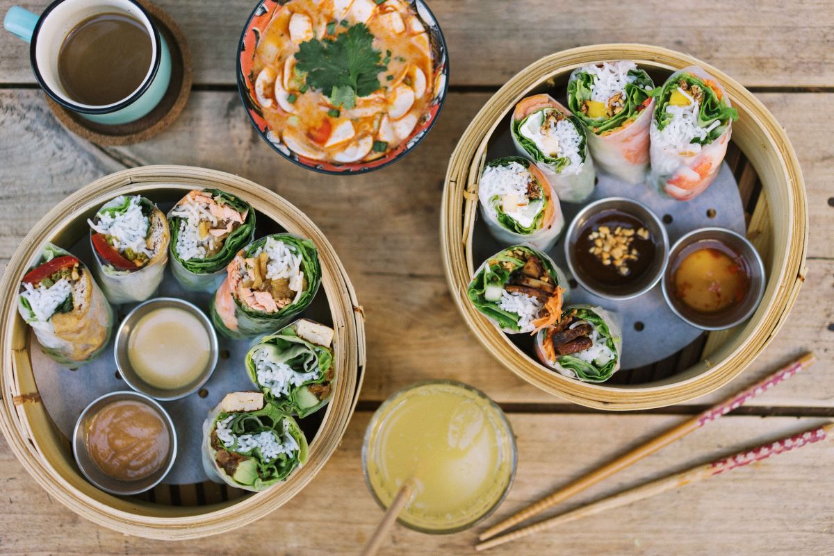 two round bamboo steamers filled with spring rolls