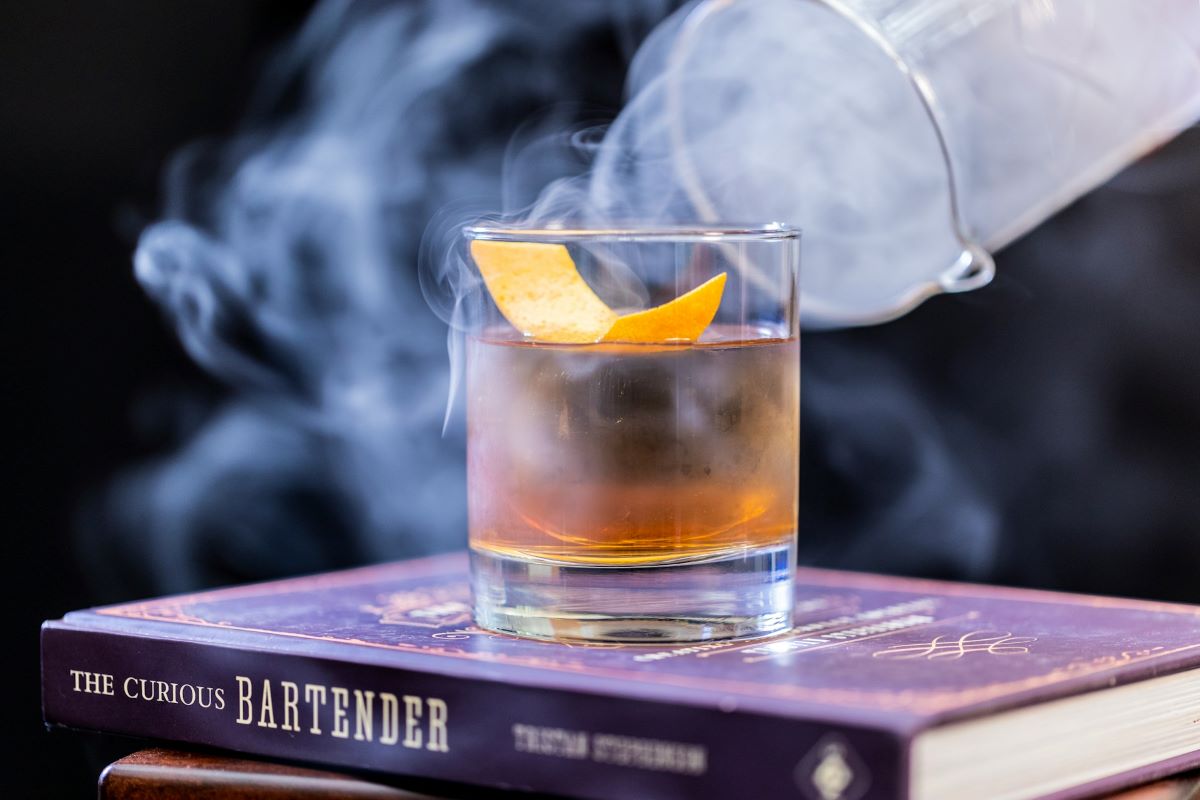 A bartender making a smokey cocktail at a secret bar. 