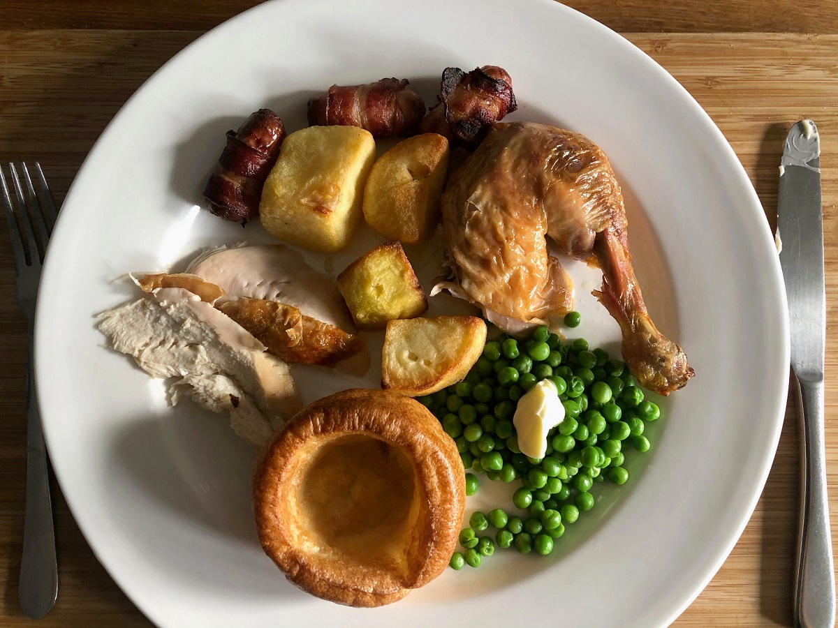 English roast dinner with chicken pease potatoes sausages and bacon