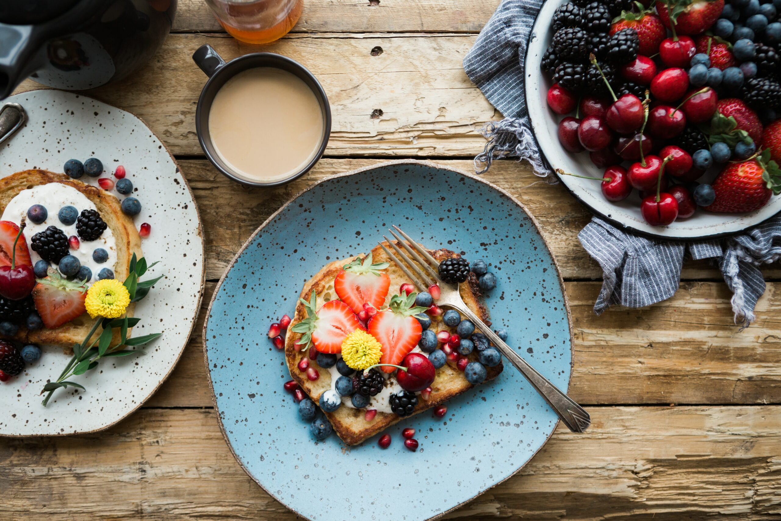 French toast with strawberries, blueberries and blackcurrants on a blue plate 