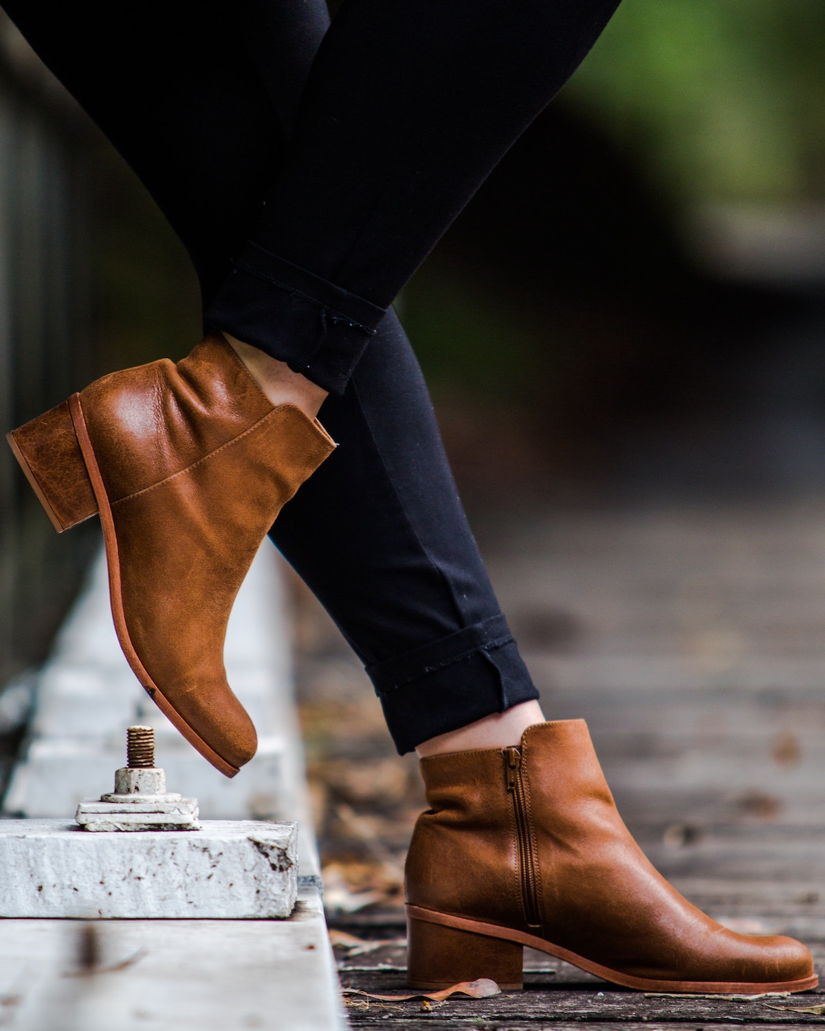 Close up of a person's feet clad in brown leather ankle boots