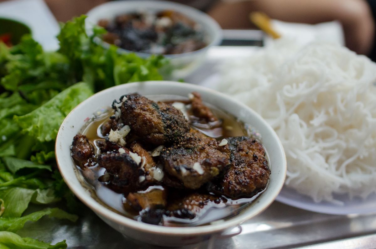 A bowl filled with Vietnamese grilled pork and noodles,