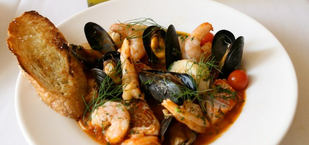 Seafood stew with shrimp, mussels, and fish in a tomato broth sprinkled with fresh herbs