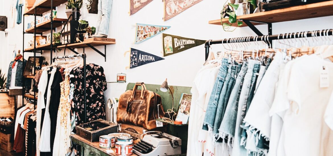 Interior of a clothing boutique with racks of clothes and decor on the walls