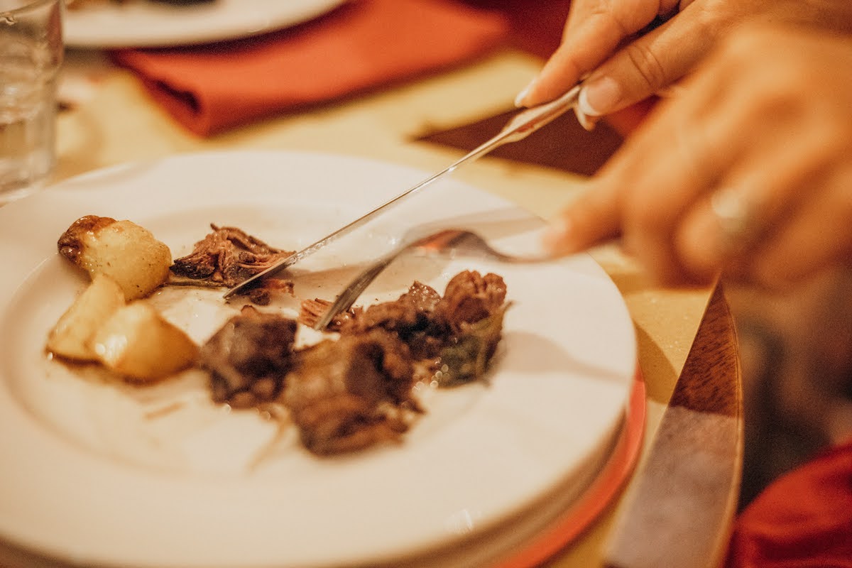 Close up of meat being cut on a plate