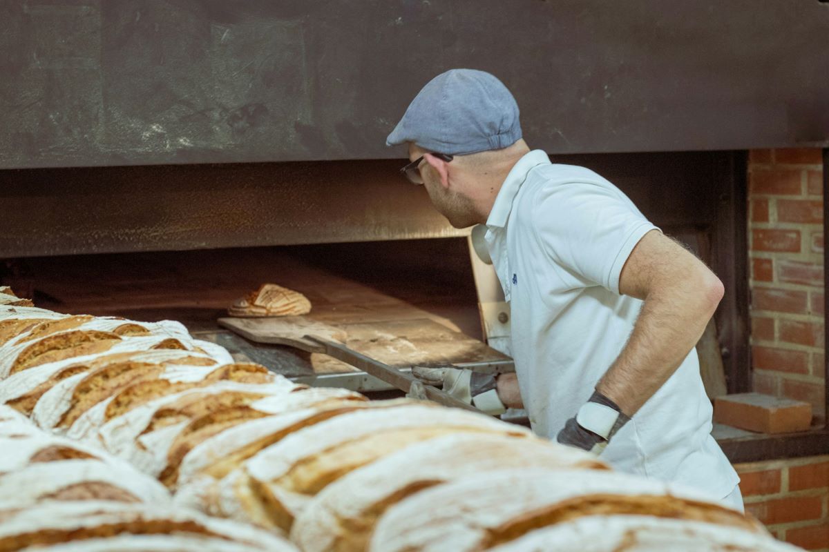 A baker making freshly baked loaves of sourdough in Lisbon. 