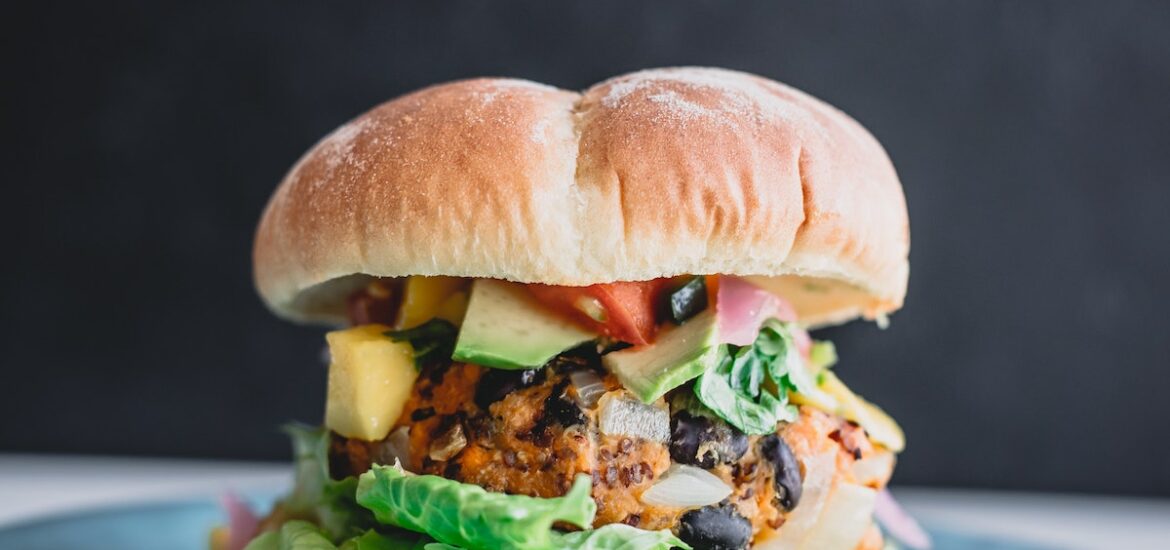 Close up of a loaded veggie burger on a blue plate