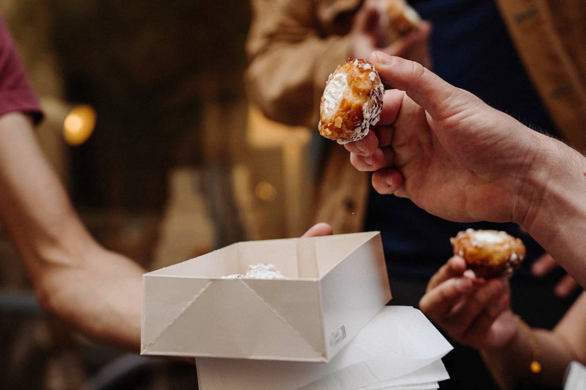 Guests holding Dunes Blanches pastries on the streets of Bordeaux.