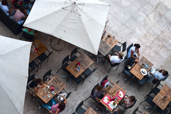 People sitting for lunch at the outdoors of a café in Lisbon. Eat like a local in Lisbon!