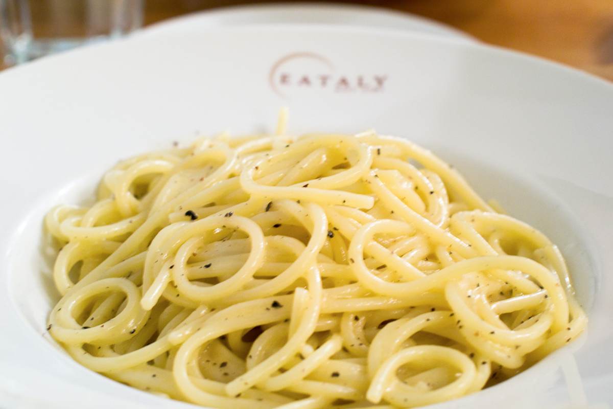 Spaghetti noodles with a light cheese and pepper sauce on a white plate