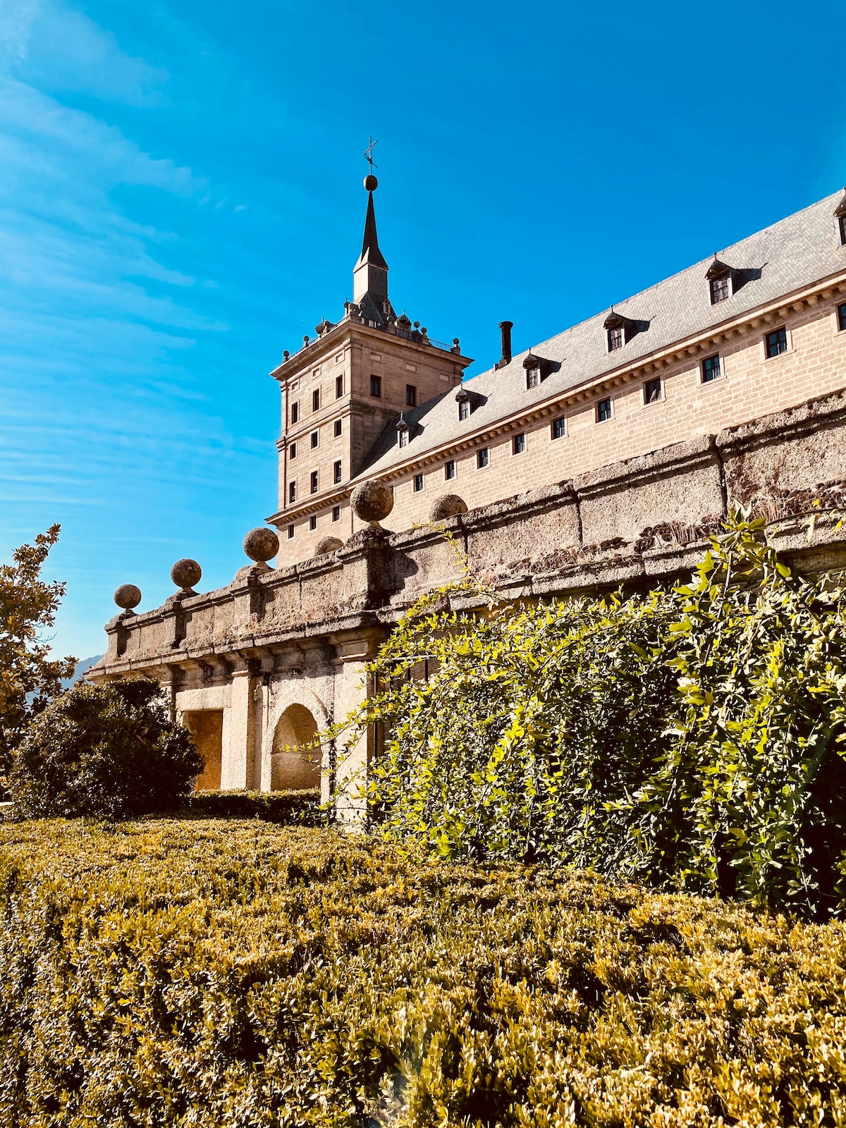 Large brown monastery with a stone tower on a clear day.