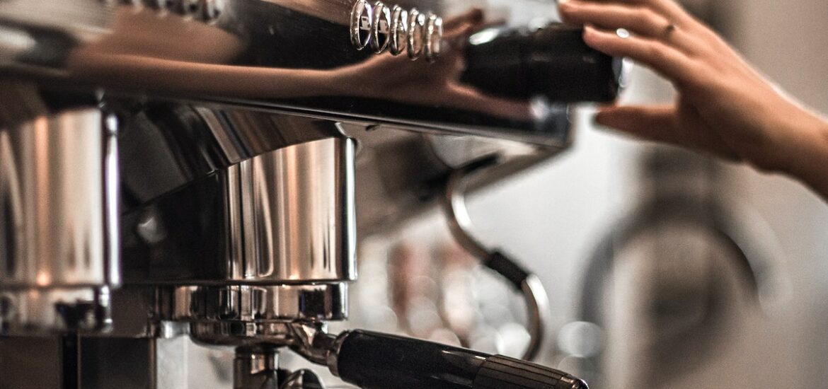 Espresso being made at a cafe into a small glass cup