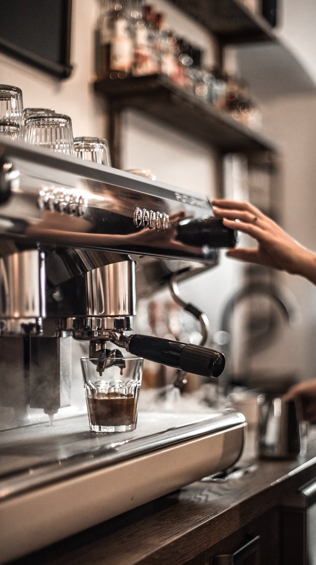 Espresso being made at a cafe into a small glass cup