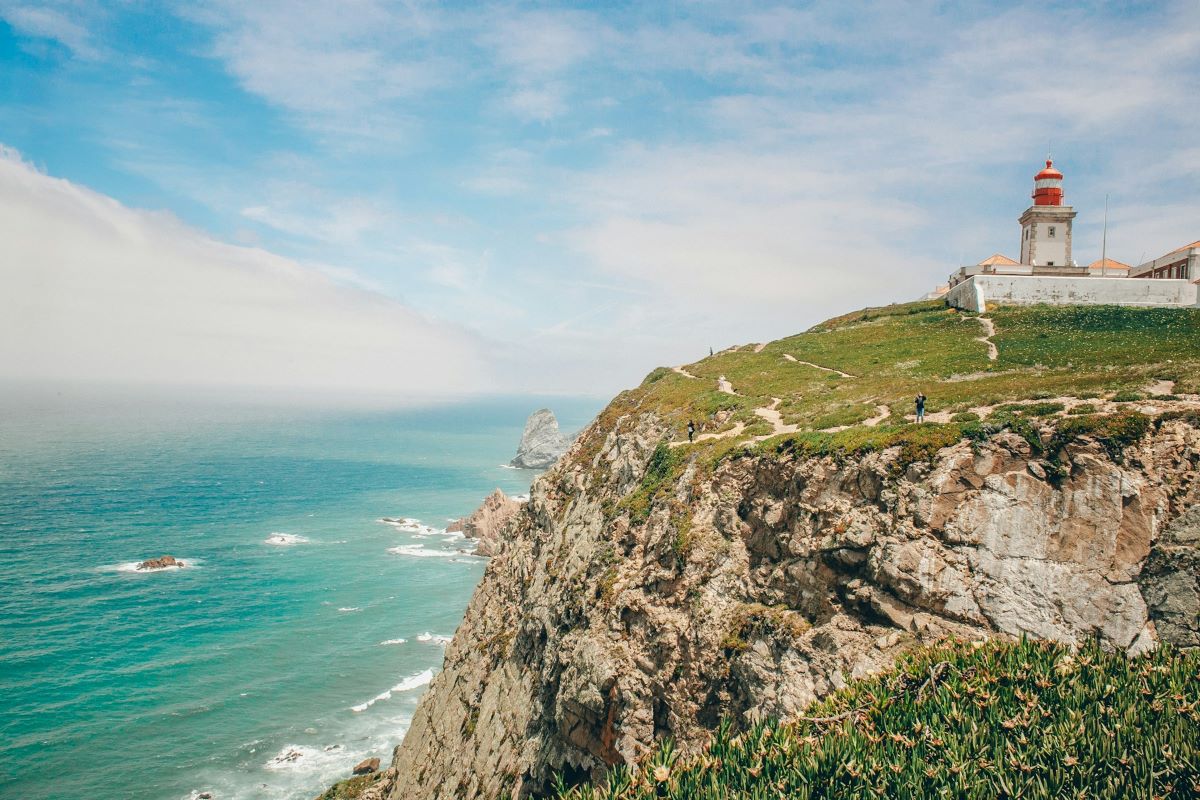 The Cabo da Roca Lighthouse on a cliff side overlooking the ocean. 