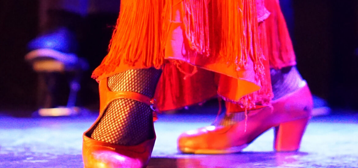 Female flamenco dancer's feet clad in red dancing shoes.