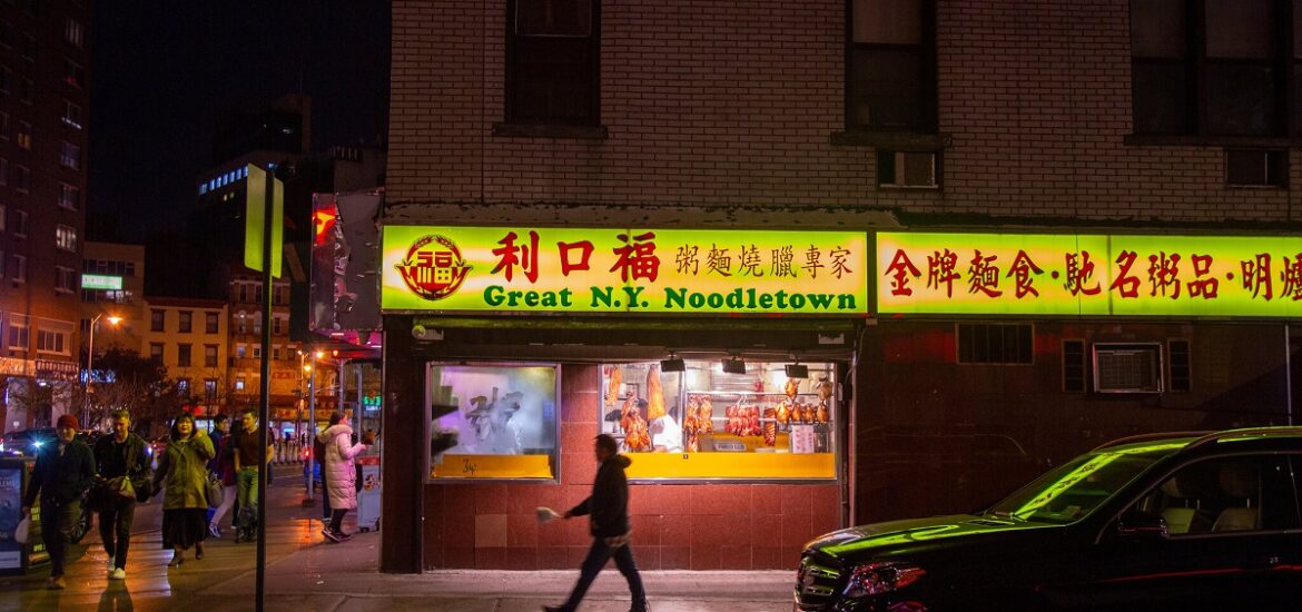 Man walks outside of Chinese restaurant in Manhattan's Chinatown at night