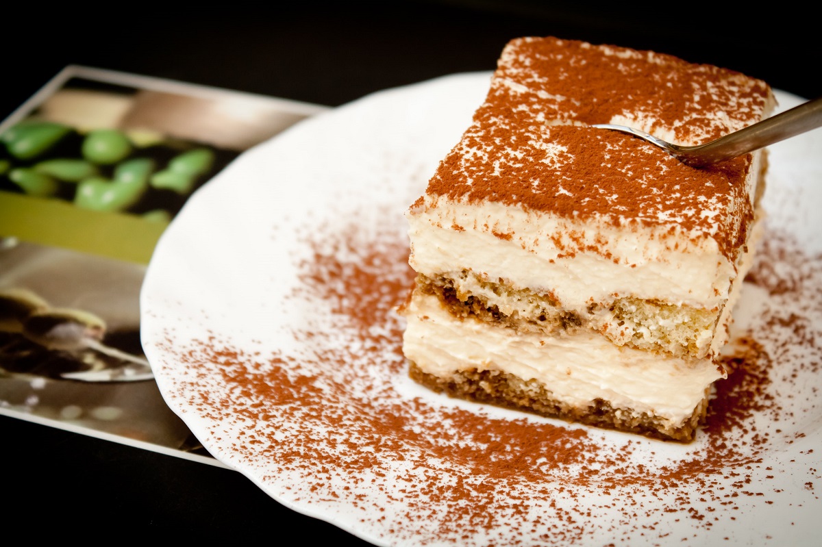 Small plate with a slice of tiramisu cake and cinnamon