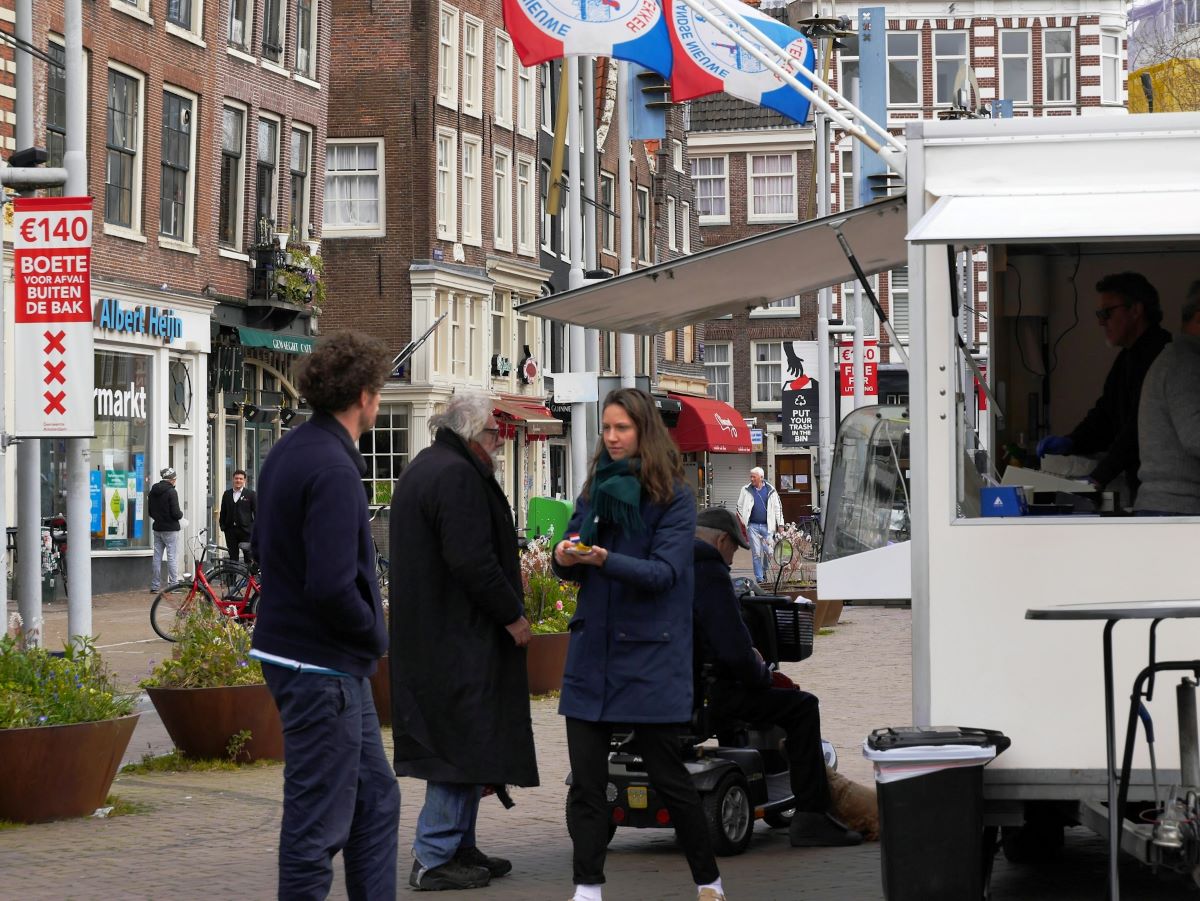 People waiting in a line at a food stand. 