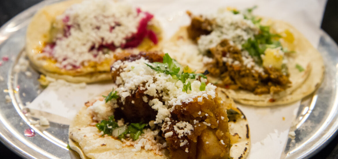 three tacos with different toppings on a round platter