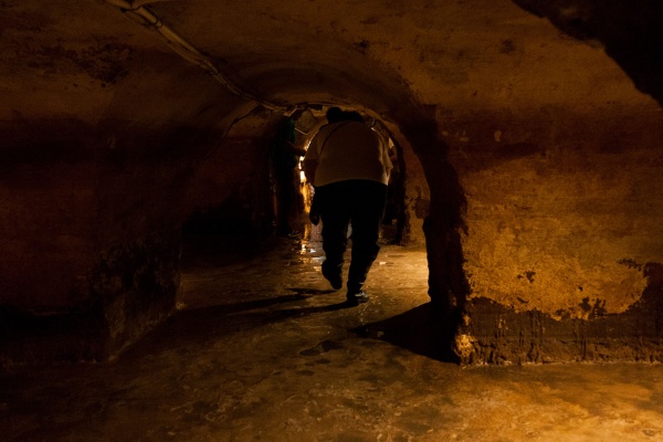 A guide ducking while showing the underground Roman galleries in Lisbon