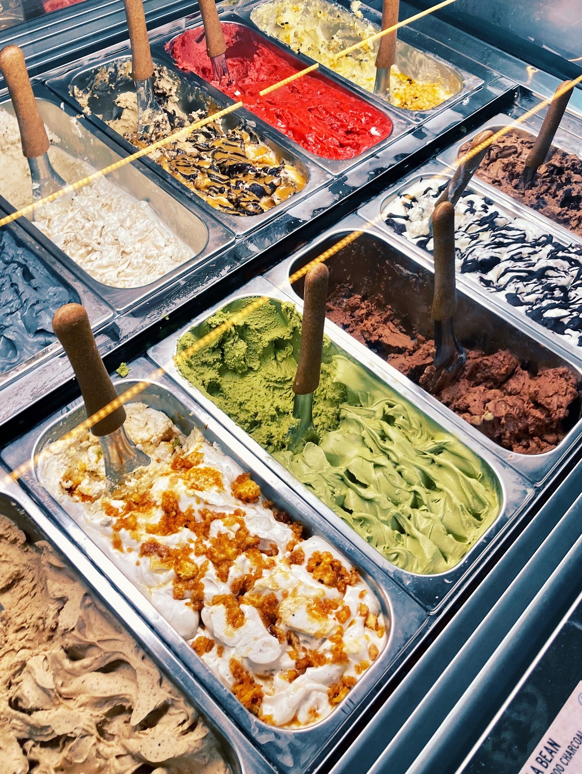 Metal bins with gelato on display in many different colors