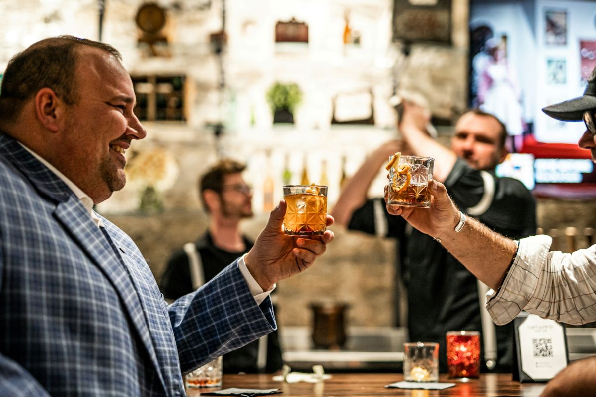 Two men cheering inside one of Bordeaux's secret speakeasies.