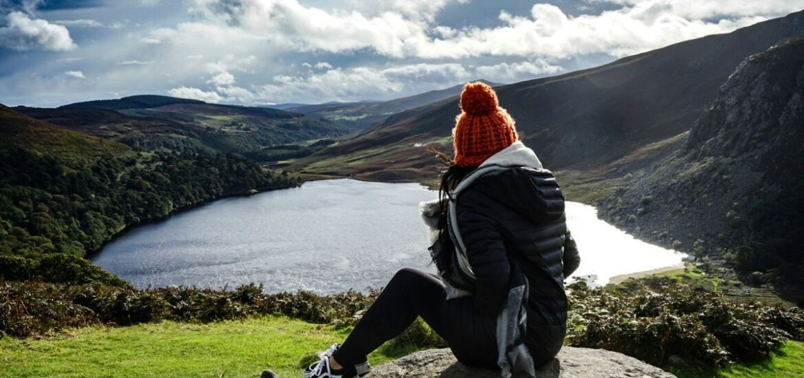 A woman on a day trip from Dublin without a car at the Wicklow Mountains on a partly cloudy day.