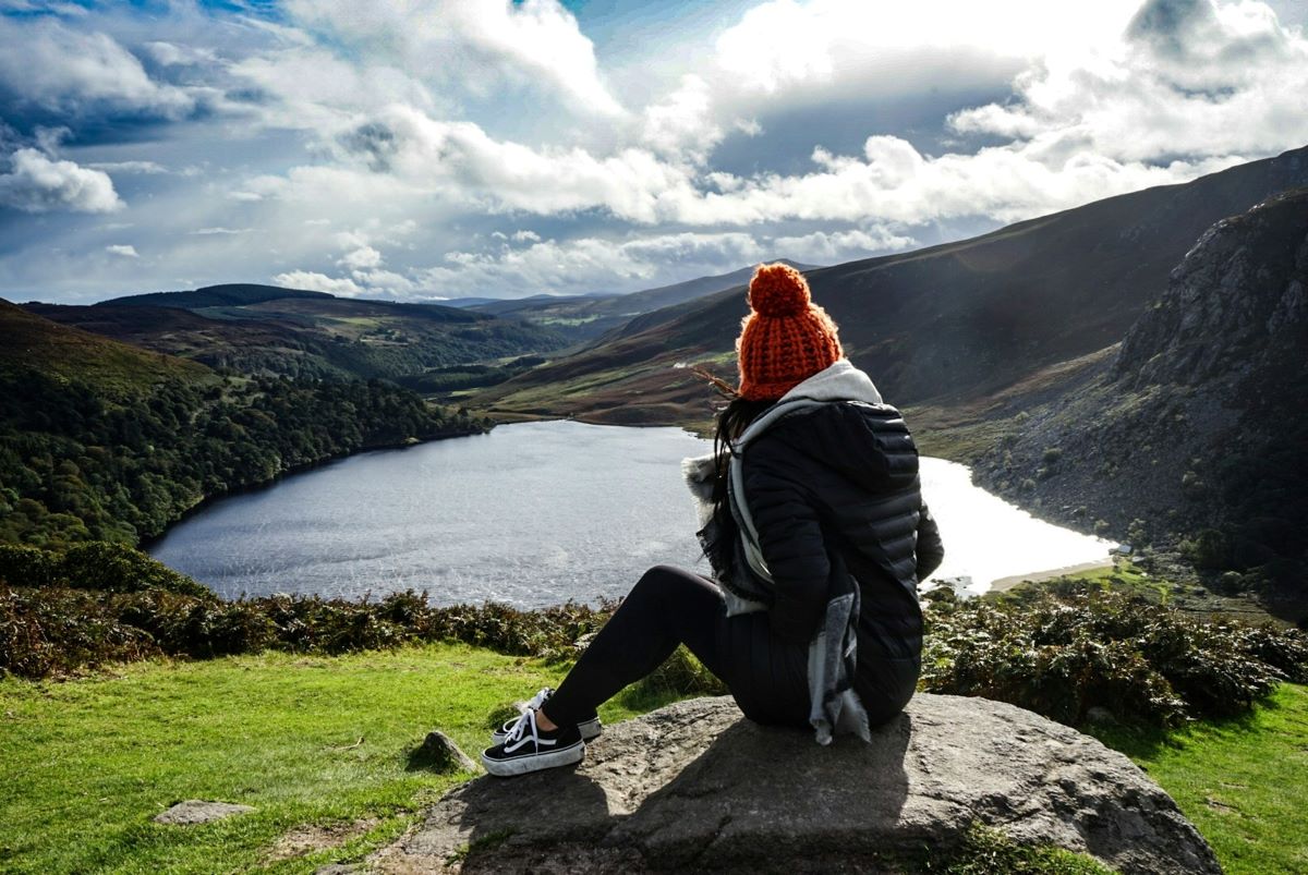 A woman on a day trip from Dublin without a car at the Wicklow Mountains on a partly cloudy day.