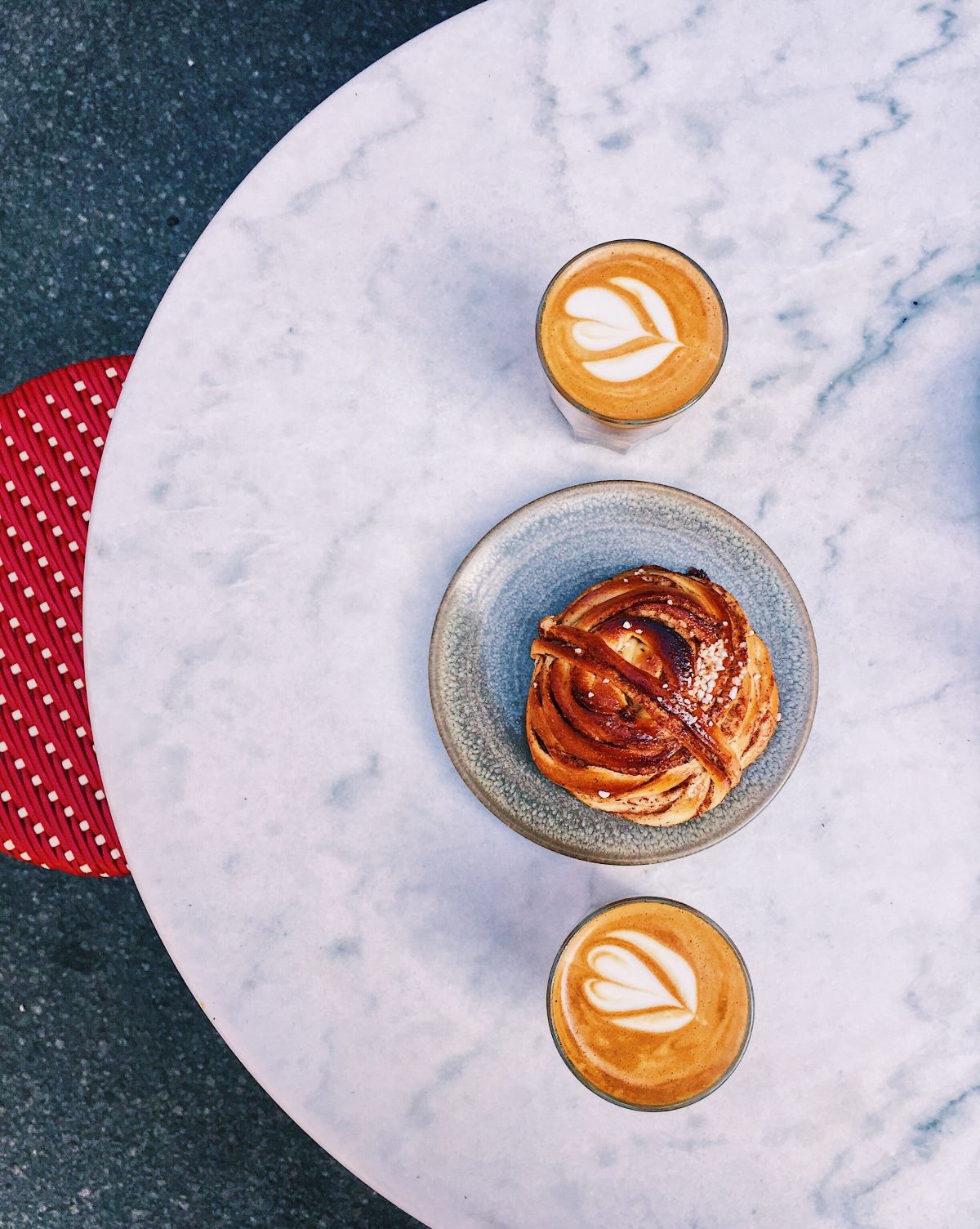 Two lattes and a plate with traditional Swedish kanelbulle