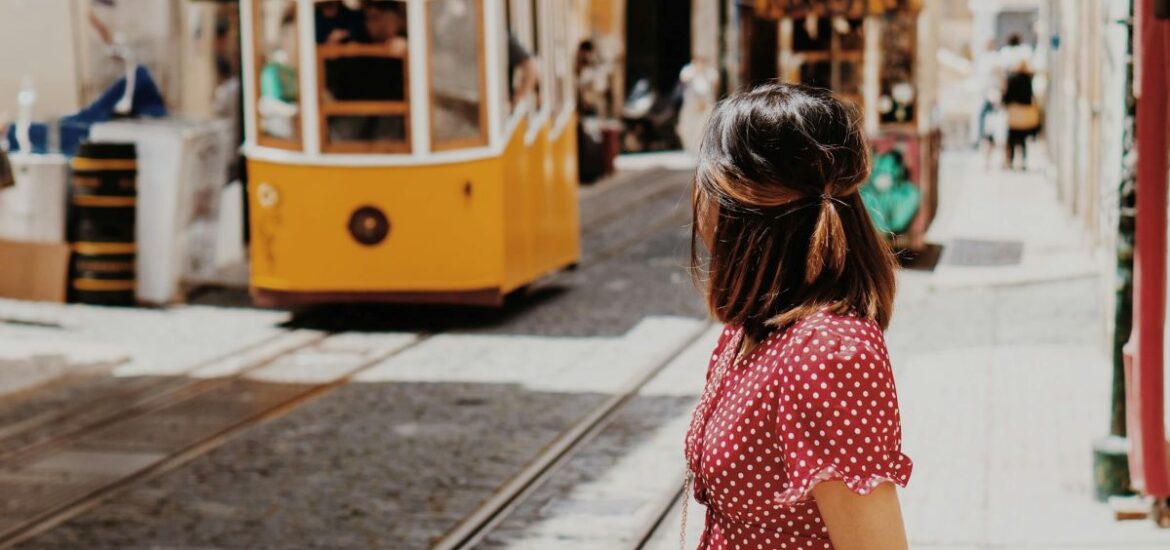 A woman in Lisbon in September looking at a cable car.