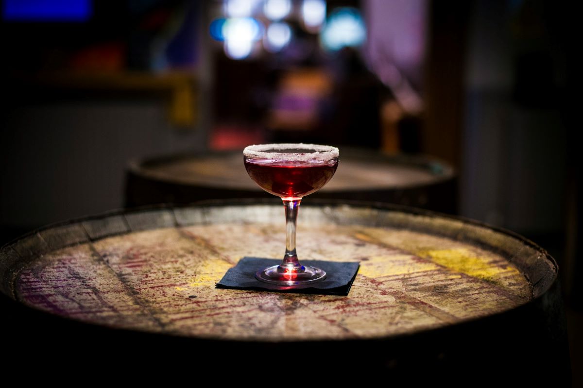 A specialty cocktail on a wooden barrel. 