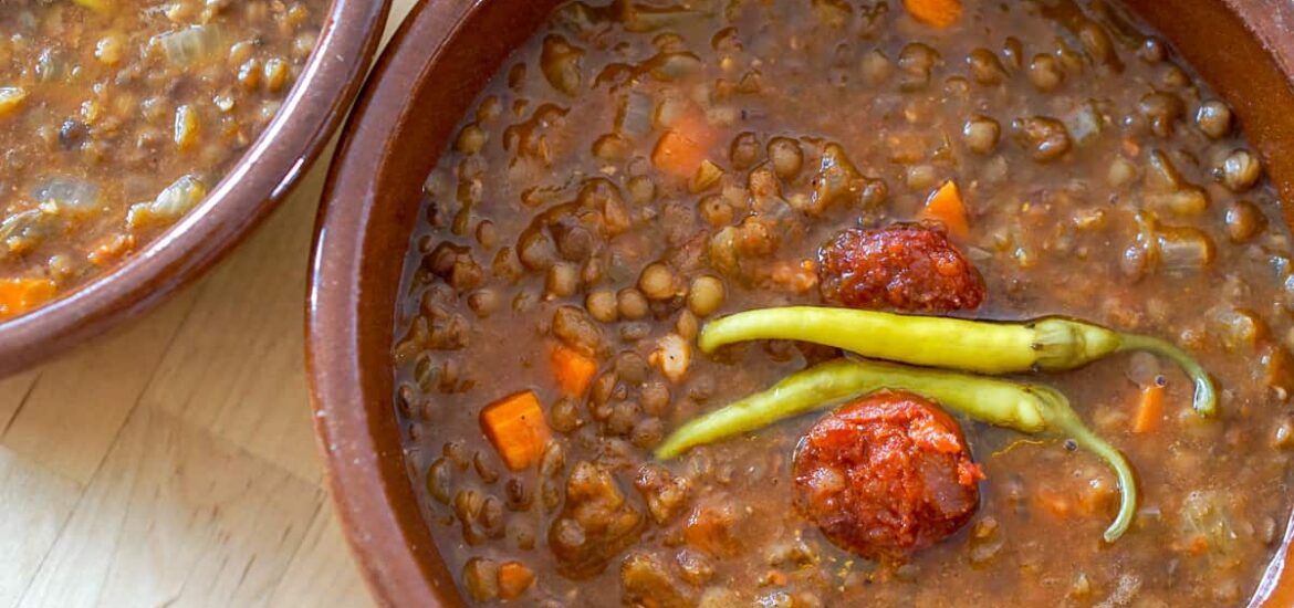 Bowl of lentil soup with chorizo and green pickled peppers