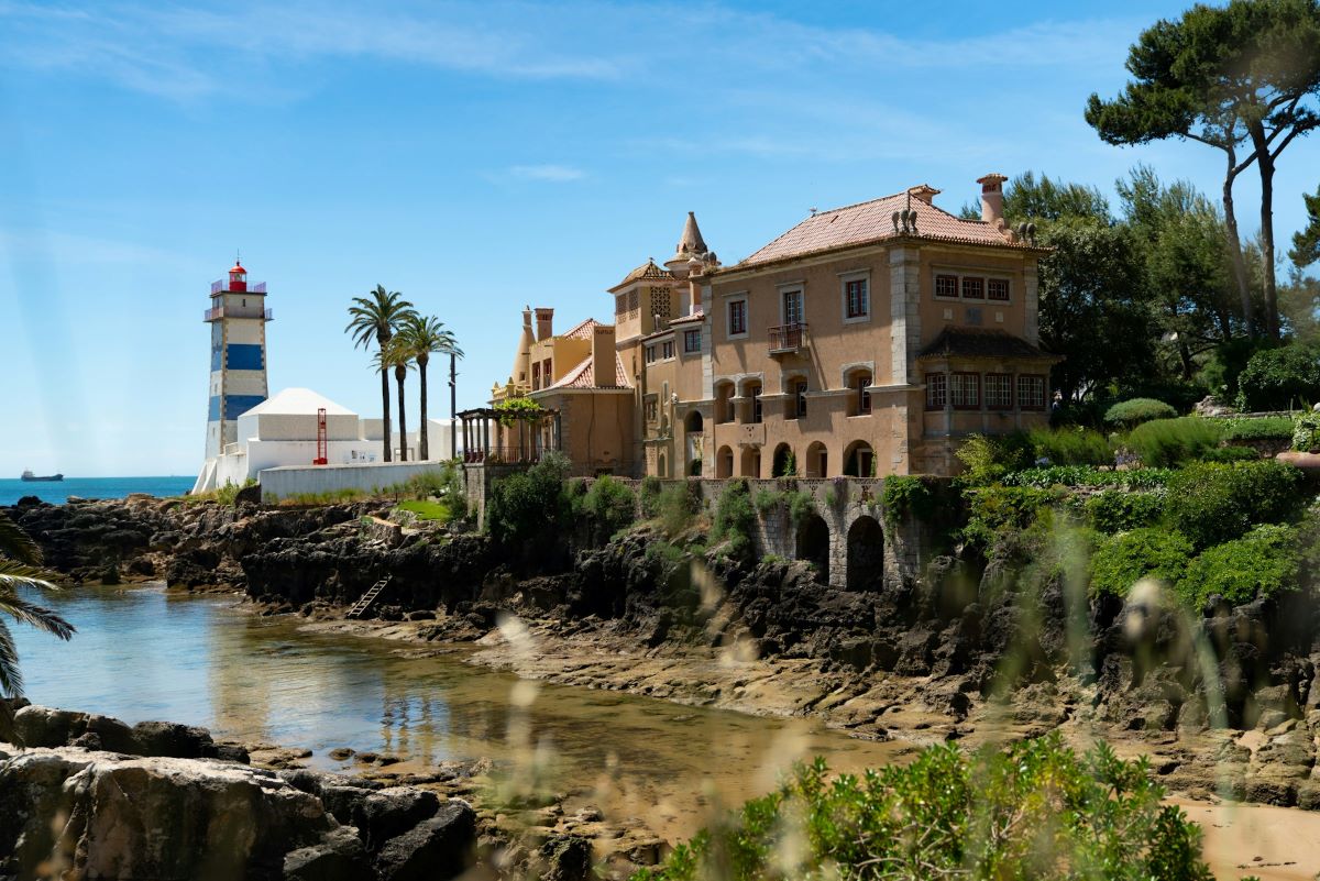 A river flowing through the town near a lighthouse in Cascais. 