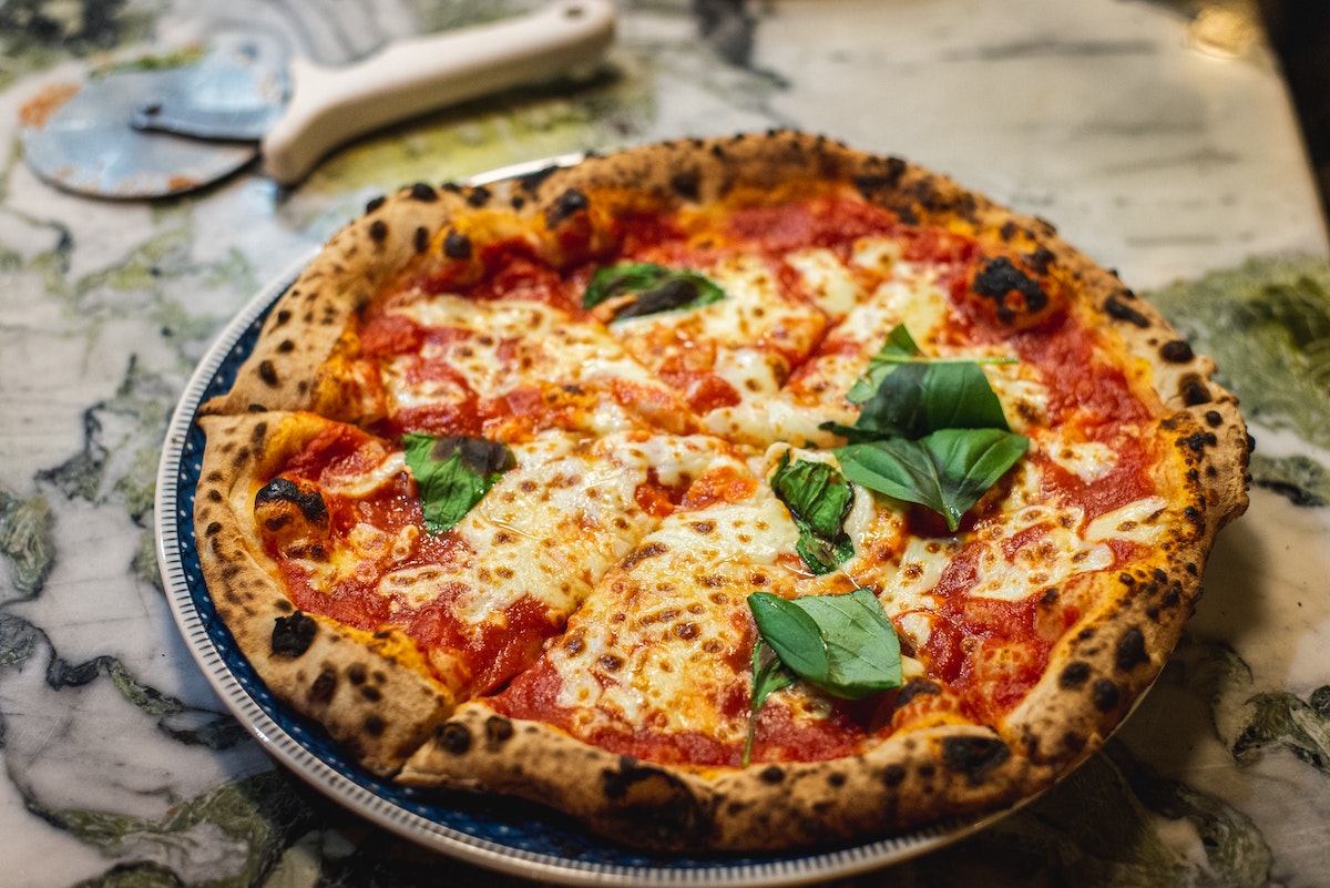 Whole pizza garnished with fresh basil