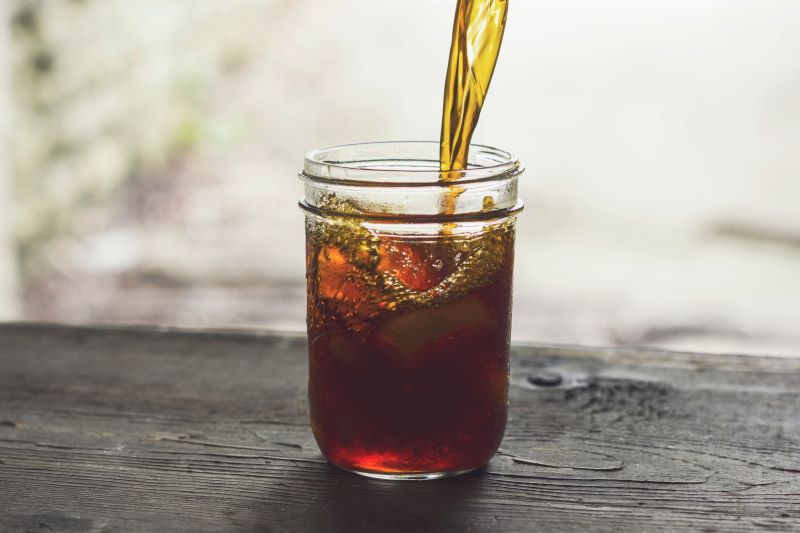 Iced tea being poured into a glass.