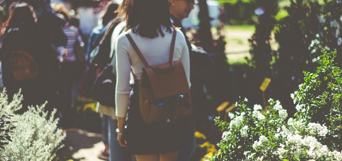 Woman with a backpack wandering through a garden or park