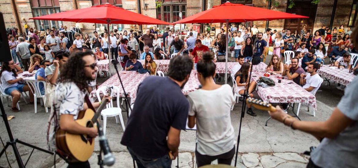 People seated at tables watching a concert performed by musicians on stage.