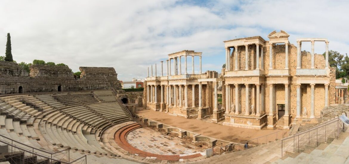 massive ampitheater surrounding a large stage with several roman columns