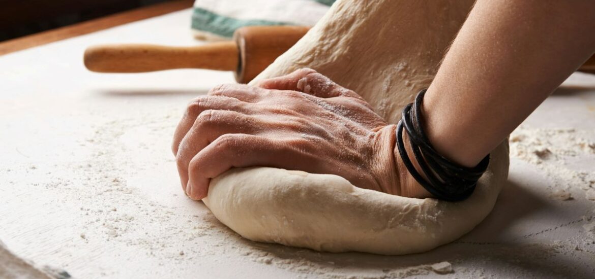 A person kneading bread dough.