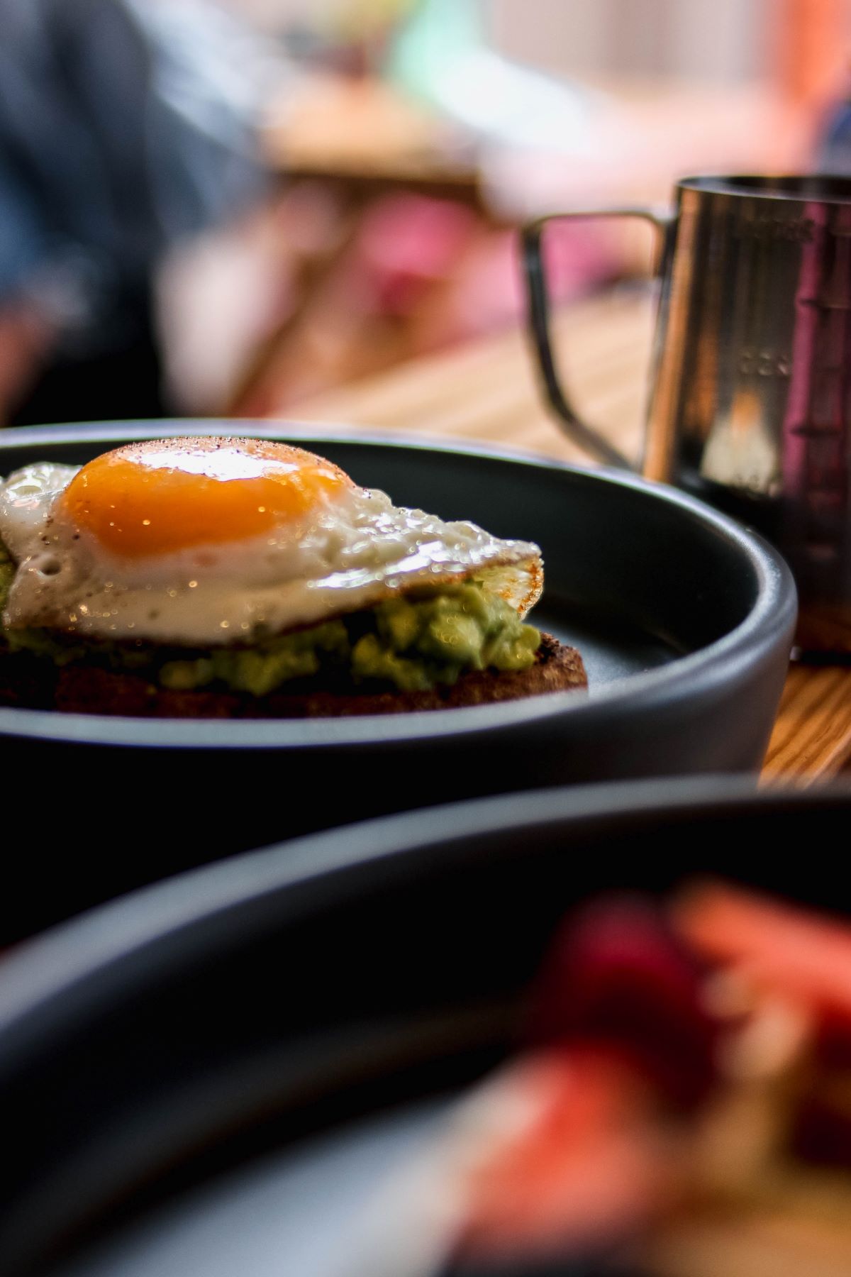 A plate with avocado toast with a fried egg on top.