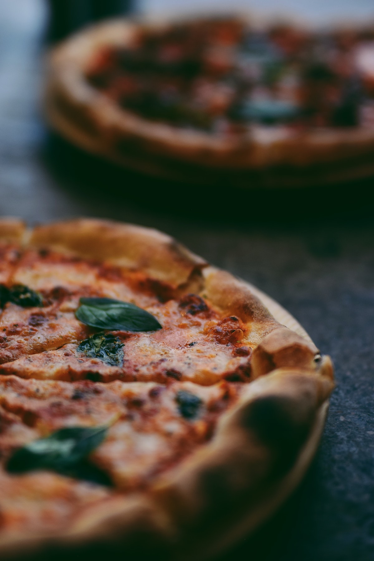 Close up of half of a thick crust pizza garnished with basil