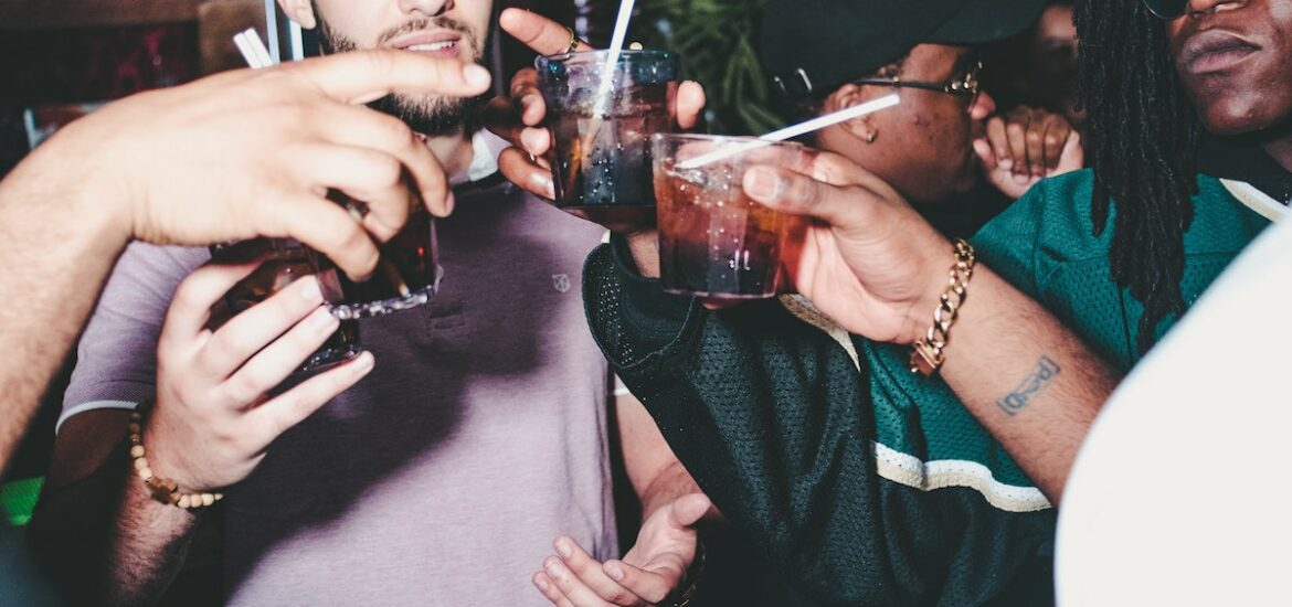 Group of men toasting with brown cocktails