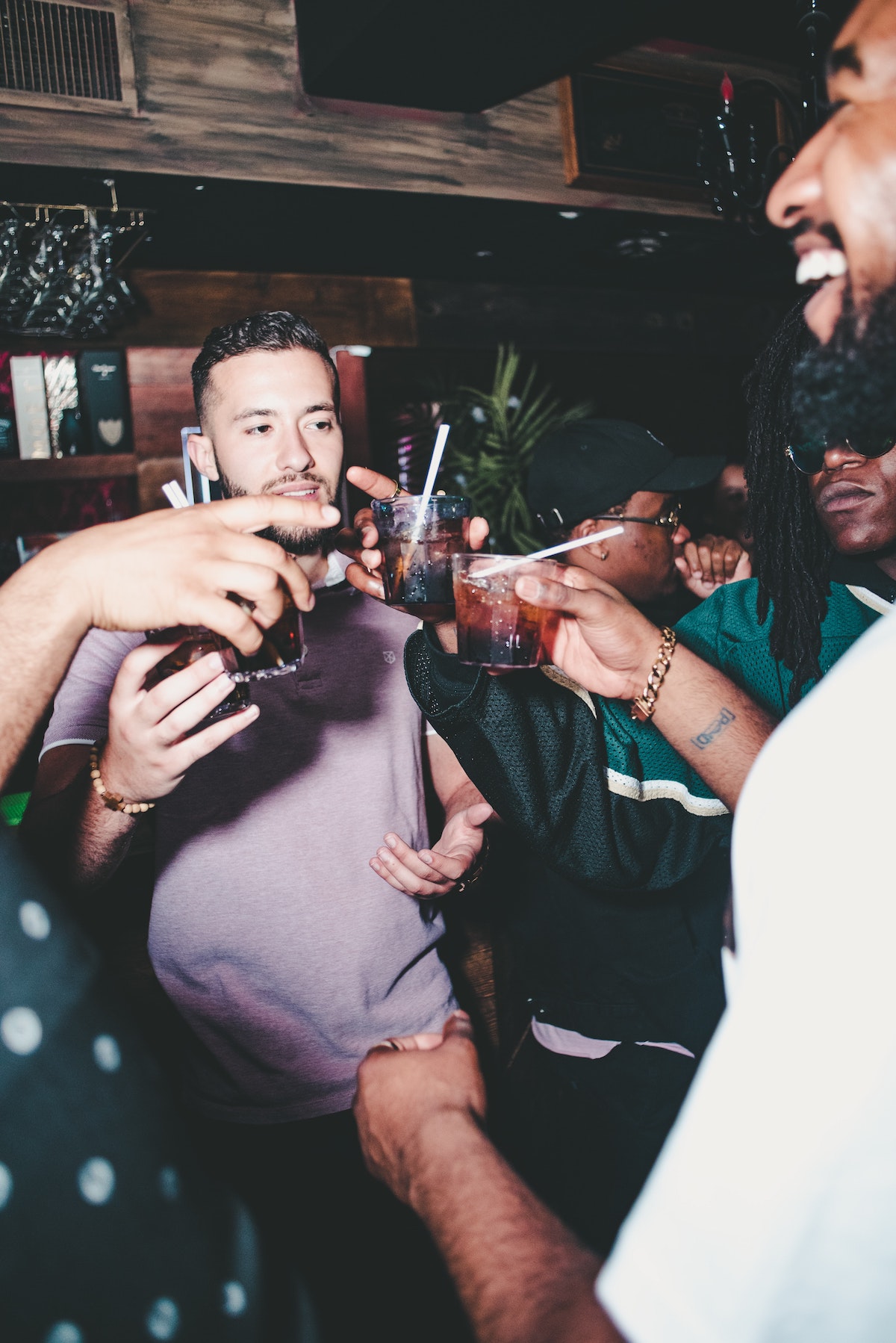 Group of men toasting with brown cocktails