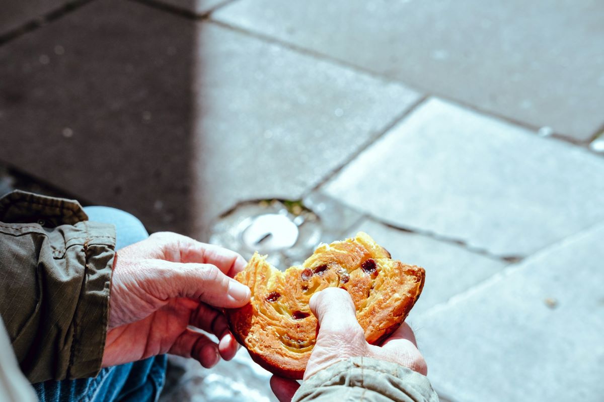 A man holding a pain aux raisin from one of the best bakeries in Paris. 